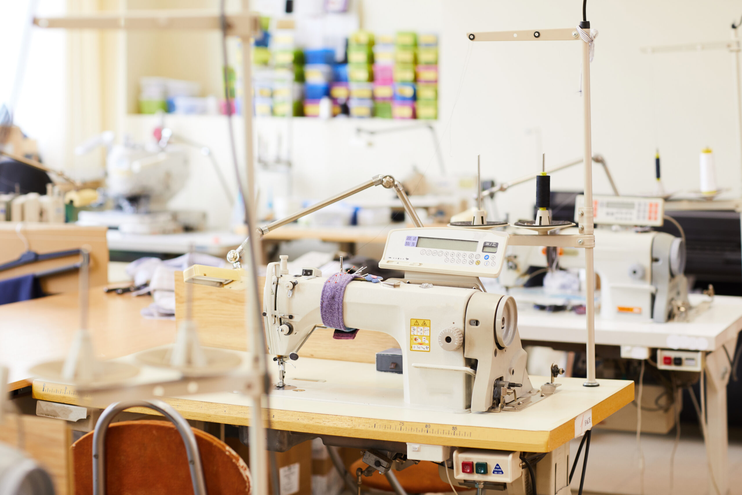 Image of modern sewing machines on work places in workshop