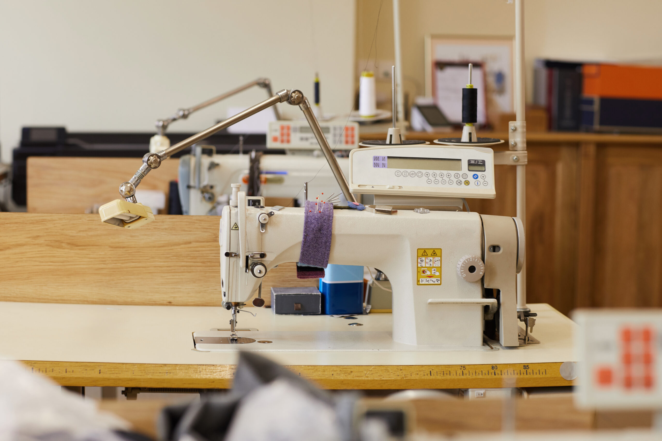 Image of sewing workshop with sewing machines on the tables ready for work