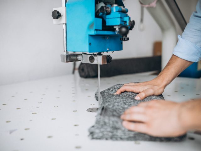 Man cutter at a sewing factory,male hands close up